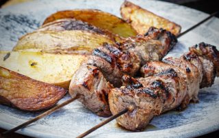 Schweinefilet-Spieße auf dem Teller serviert